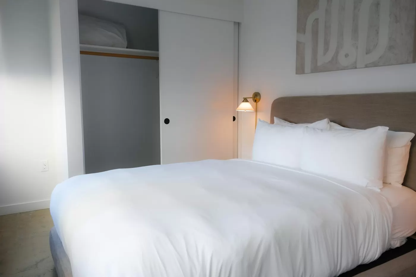 Lit préparé avec du linge blanc, standard hôtelier